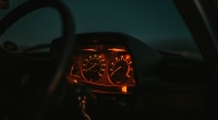 painel-de-carro-iluminado-em-vermelho-com-um-volante-a-noite
